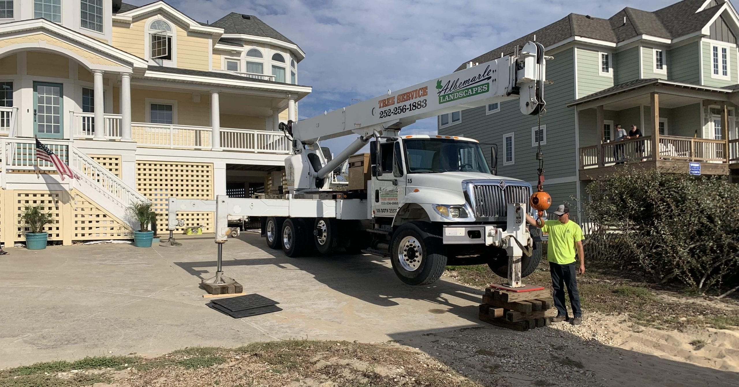 Operator using bucket boom truck for tree removal in Kitty Hawk, NC