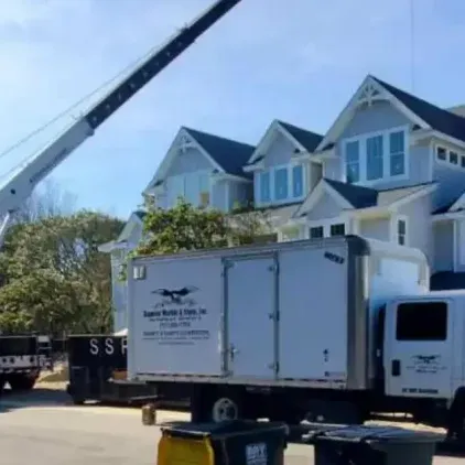 Crane rental in Coinjock, NC, lifting HVAC unit in coastal residential area