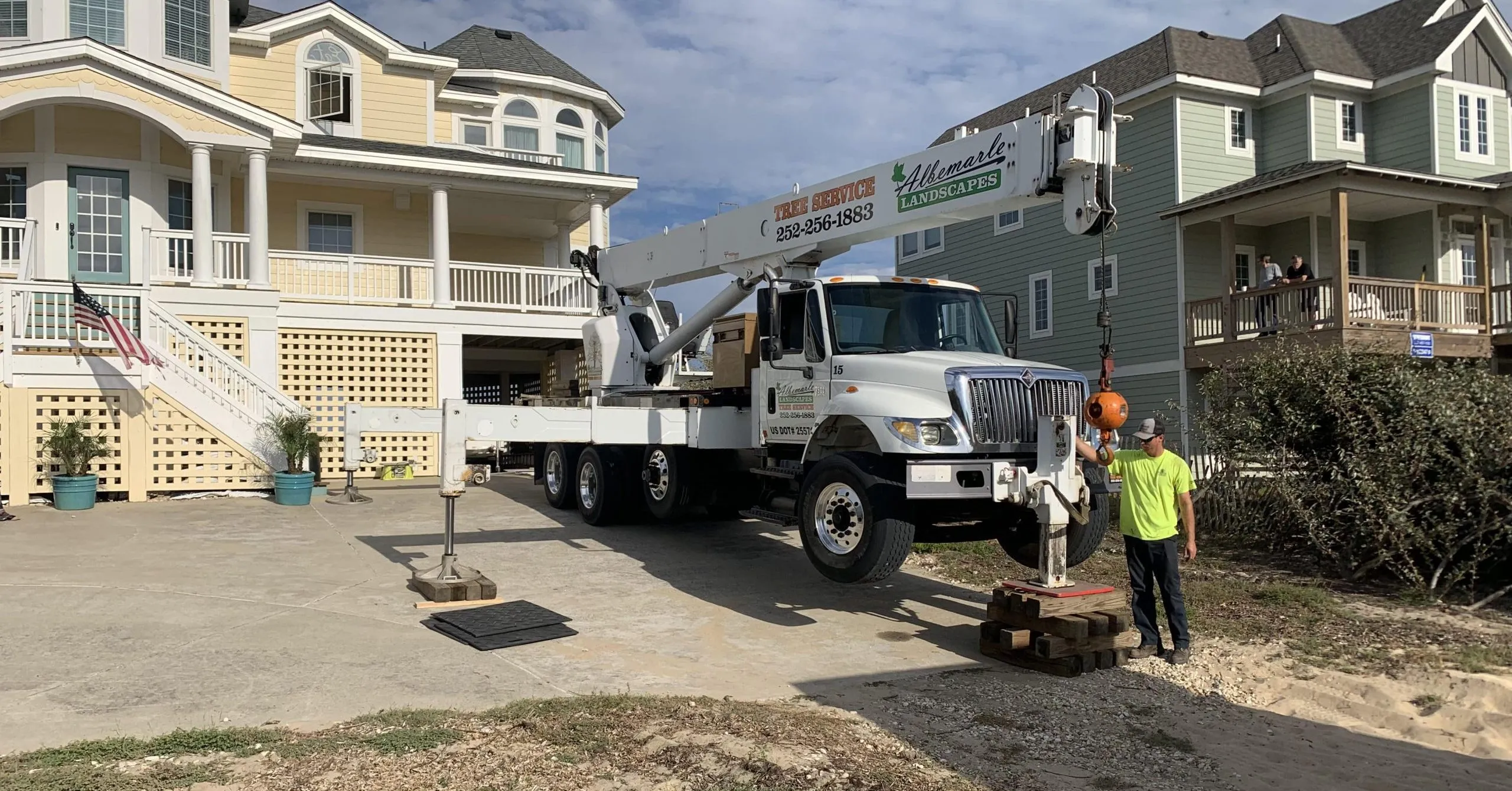 Operator using bucket boom truck for tree removal in Kitty Hawk, NC