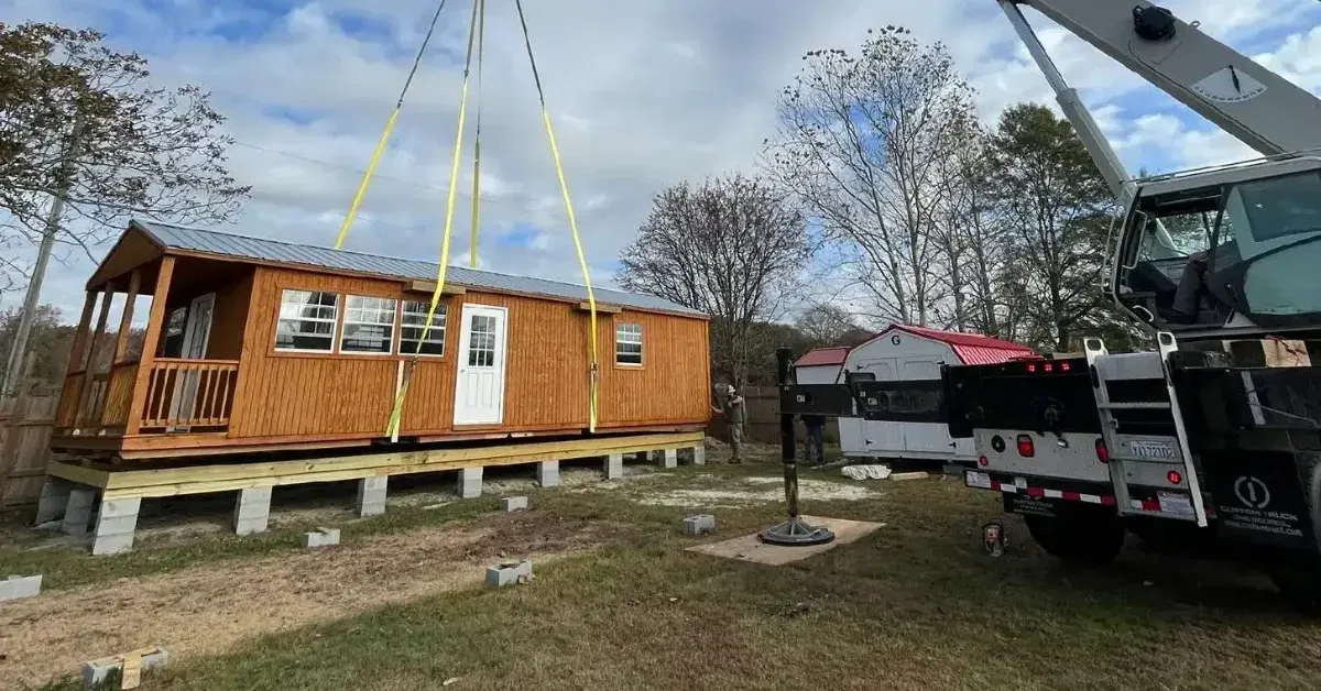 Crane placing a shipping container on a steep hillside with limited access.